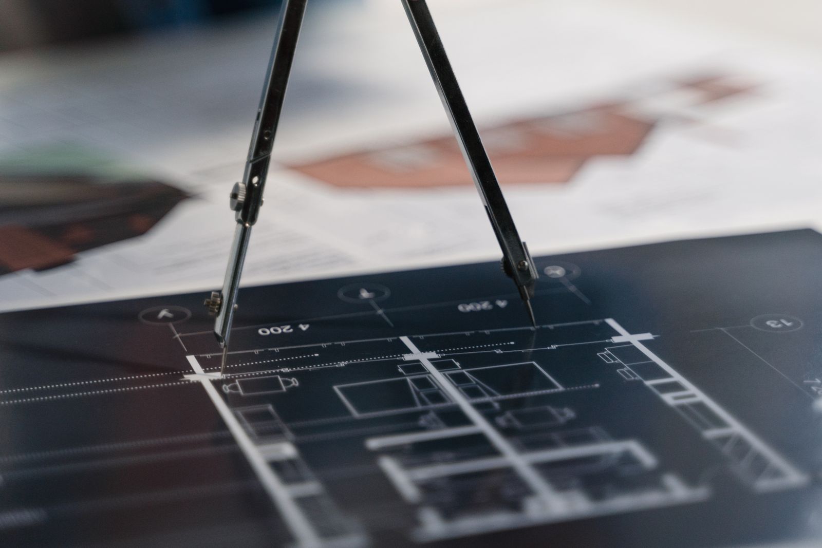 Compass resting on architectural drawings