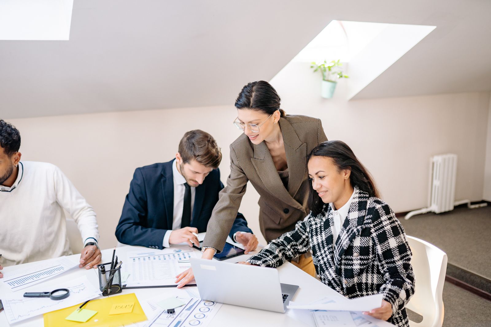 Colleagues working around a table with plans and laptops