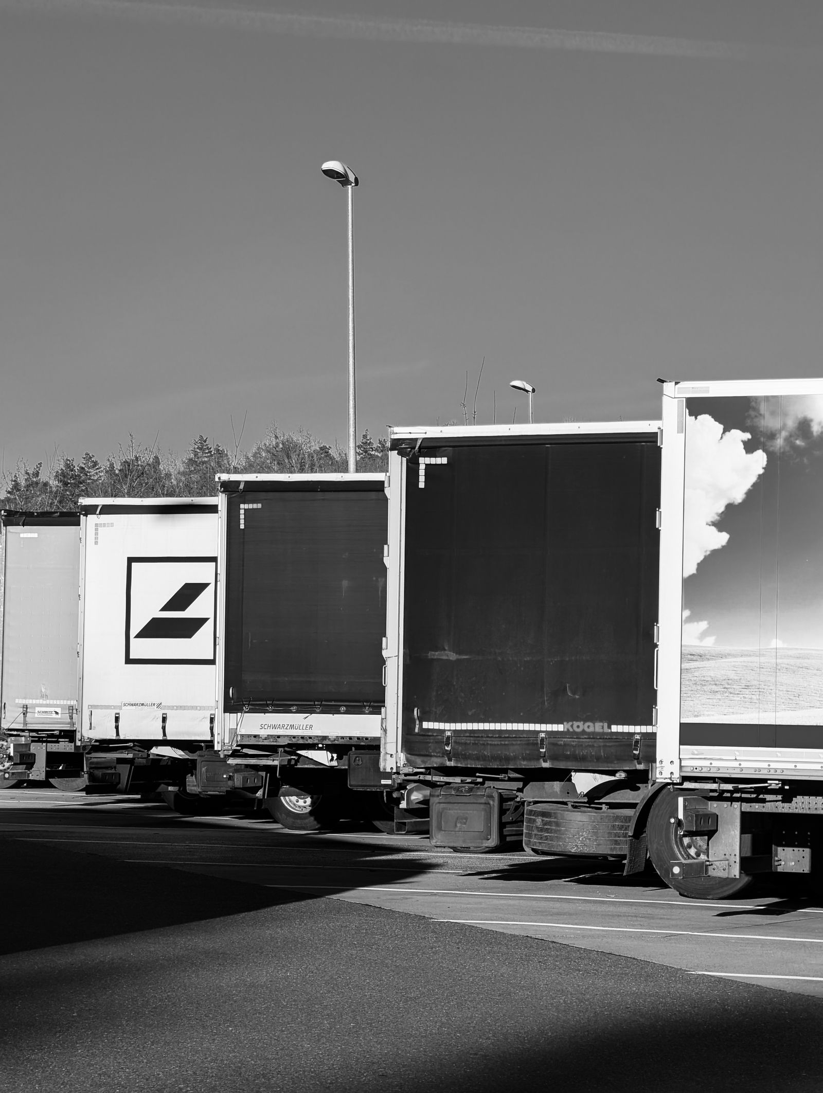 Black and white photograph of parked semi-trailers