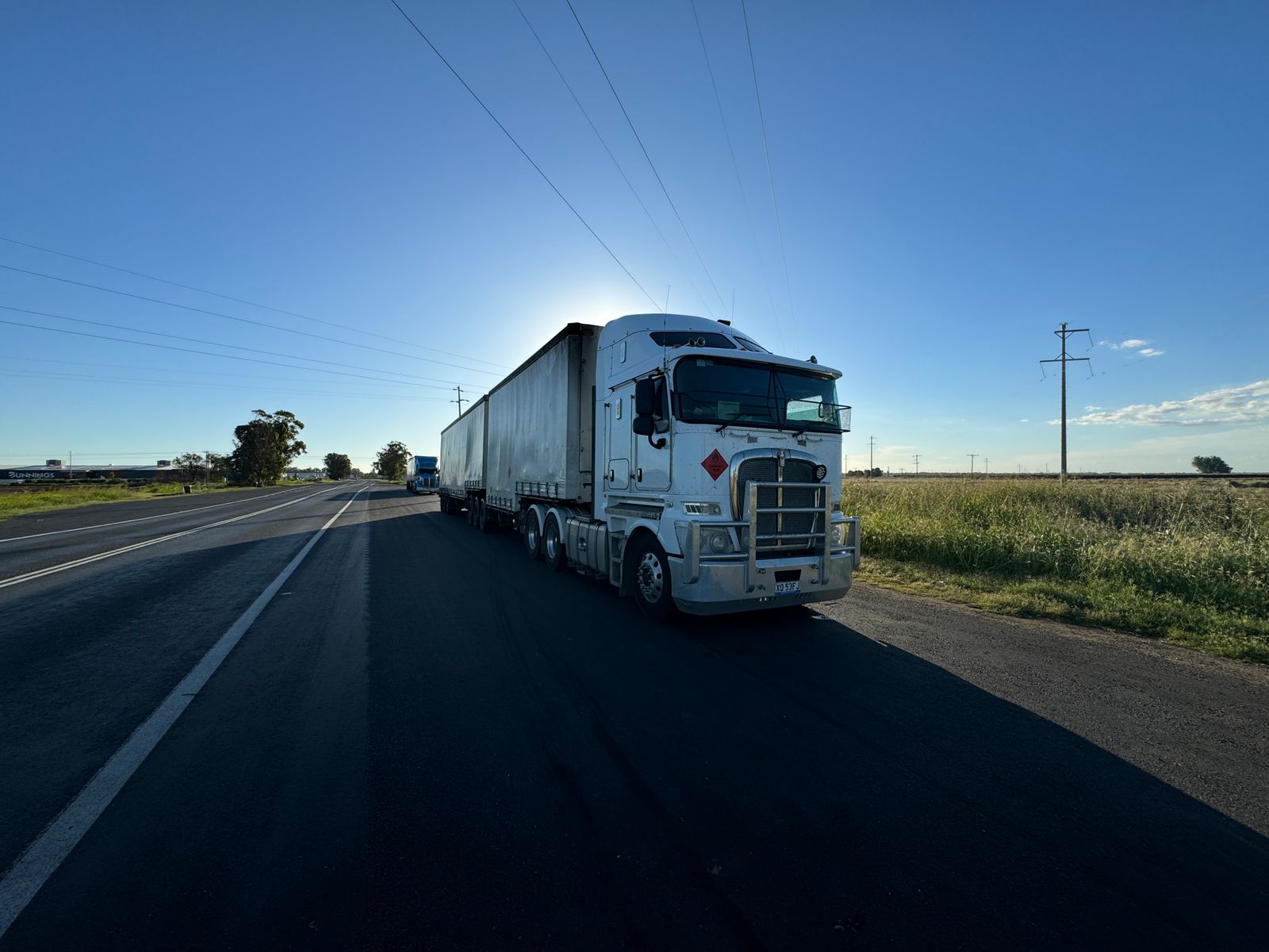 Semi-truck on an open highway under a clear sky